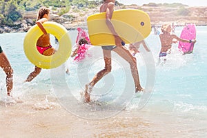 Group of kids running into sea to swim