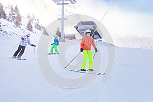 Group of kids ski downhill on Alpine resort