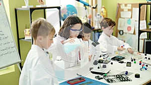 Group of kids students pouring liquid on bottl doing experiment at laboratory classroom