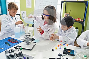 Group of kids students pouring liquid on bottl doing experiment at laboratory classroom