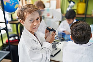 Group of kids students smiling confident using microscope at laboratory classroom