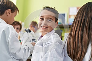 Group of kids students smiling confident using microscope at laboratory classroom