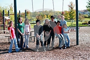 Group of kids on swingset photo