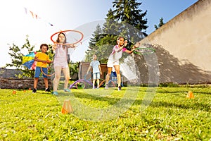 Group of kids throw hula rings to the target