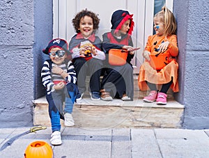 Group of kids wearing halloween costume holding pumpkin basket at street