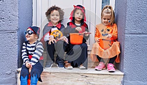 Group of kids wearing halloween costume holding pumpkin basket at street