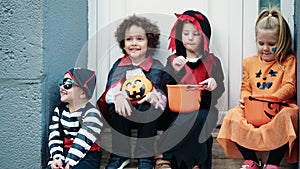 Group of kids wearing halloween costume holding pumpkin basket at street