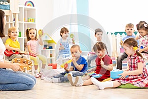 Group of kindergarten children play with musical toys. Early musical education in daycare
