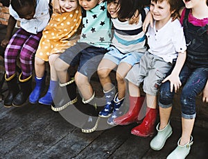 Group of kindergarten kids friends arm around sitting and smiling fun