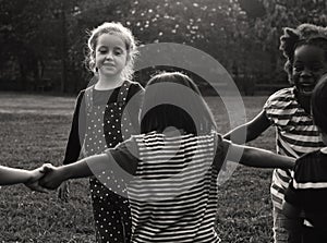 Group of kindergarten kids friends holding hands playing at park