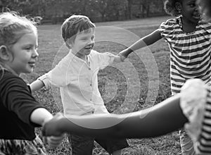 Group of kindergarten kids friends holding hands playing at park