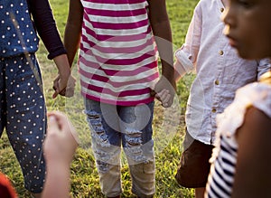 Group of kindergarten kids friends holding hands playing at park