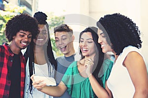 Group of latin american and african young adults watching clip