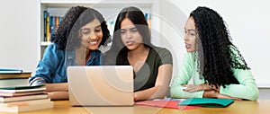 Group of latin american and indian students learning at computer