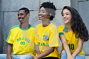 Group of laughing football fans from Brazil with yellow soccer jersey