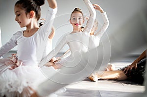Group of little ballerinas girls doing exercises in dance school