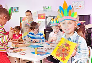 Group of little children glue and draw in class