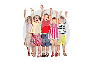 Group of little children raising hands up and smiling