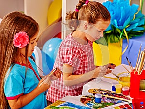 Group little girl with brush painting in kindergarten .