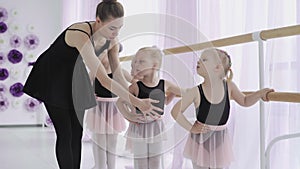 Group of little girls learning new dance moves during ballet lesson