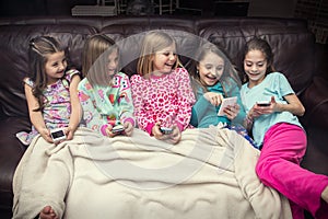 Group of little girls playing with their electronic mobile devices