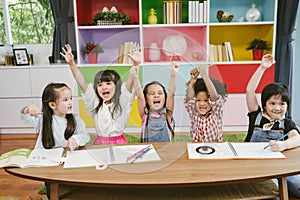 Group of little preschool kids hands up in class . portrait of children diversity education concept.