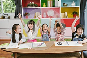 Group of little preschool kids hands up in class . portrait of children diversity education concept. photo