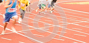 A group of male athletes running on the track, the fuzzy movement