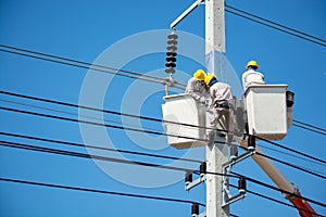 Group of Male Engineer or Electrician working on Crane Bucket over Electrical Pole