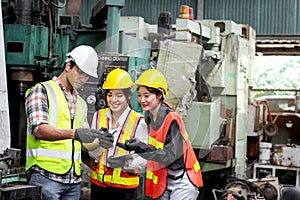 Group of male and female industrial engineer workers with helmet and safety vest inspecting engine at manufacturing plant industry