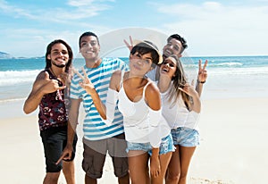 Group of male and female young adults dancing at beach