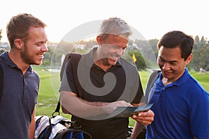 Group Of Male Golfers Marking Scorecard At End Of Round