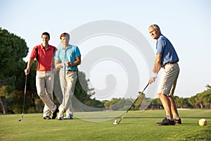 Group Of Male Golfers Teeing Off