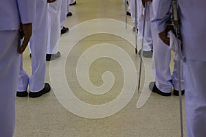 A group of male officials wearing white robes stood at a distance.