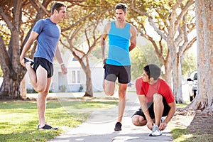 Group Of Male Runners Warming Up Before Run