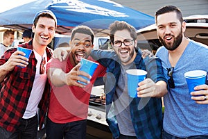 Group Of Male Sports Fans Tailgating In Stadium Car Park