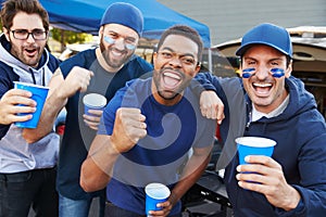 Group Of Male Sports Fans Tailgating In Stadium Car Park