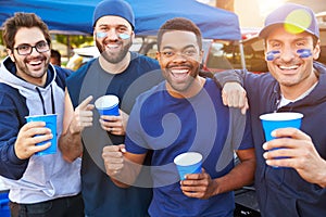 Group Of Male Sports Fans Tailgating In Stadium Car Park