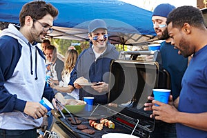 Group Of Male Sports Fans Tailgating In Stadium Car Park photo