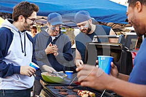 Group Of Male Sports Fans Tailgating In Stadium Car Park