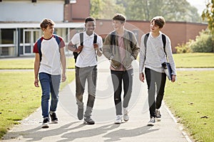 Group Of Male Teenage Students Walking Around College Campus