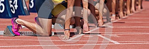 Group of male track athletes on starting blocks