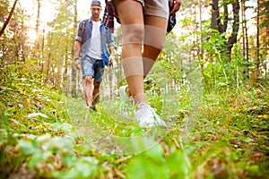 Group of man and women during hiking excursion in woods, walking while enjoying their journey