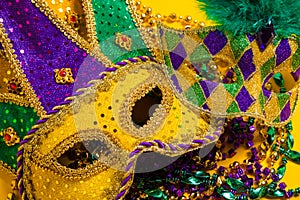 Group of Mardi Gras Masks on yellow Background wtih beads