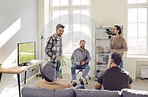 Group of mature bearded friends talking during football match on tv at home with beer.