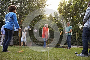 Group Of Mature Friends Playing Croquet In Backyard Together