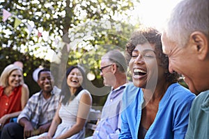 Group Of Mature Friends Socializing In Backyard Together