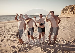 Group of mature happy active adults having fun in the beach. Long time friends