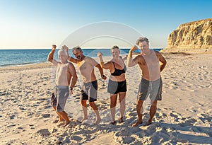 Group of mature happy active adults having fun in the beach. Long time friends