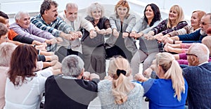 A group of mature mature people stretched their arms forward sit